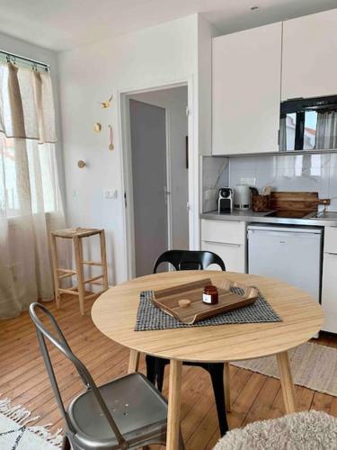 une cuisine avec une table et des chaises dans une pièce dans l'établissement Gîte Au numéro 13 à 50m de la mer, à La Bernerie-en-Retz