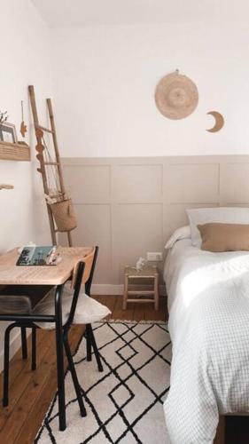 une chambre avec un lit, une table et une chaise dans l'établissement Gîte Au numéro 13 à 50m de la mer, à La Bernerie-en-Retz