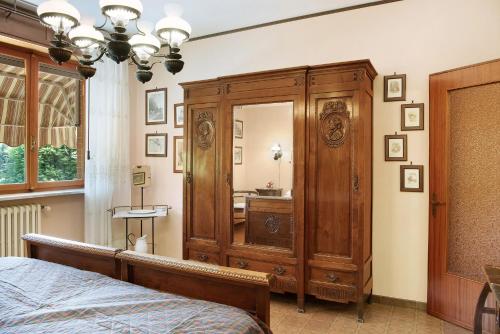 a bedroom with a large wooden cabinet and a mirror at Appartamento Iris in Cisterna dʼAsti
