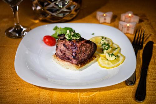 a plate of food with a piece of meat and vegetables at Casa Maria Arges in Piteşti