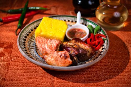 a plate of food with meat and vegetables on a table at Casa Maria Arges in Piteşti