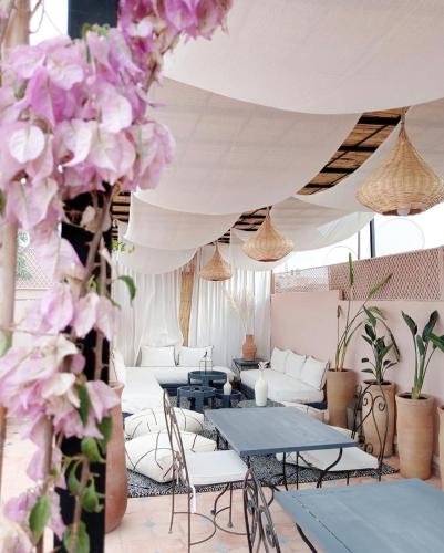 a room with tables and chairs and flowers at Riad Jonan & Spa in Marrakech