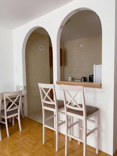 eine Küche mit 3 Stühlen, einem Tisch und einer Theke in der Unterkunft Apartment Varezić in Plužine