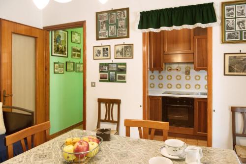 a kitchen with a table with a bowl of fruit on it at Appartamento Glicine in Cisterna dʼAsti