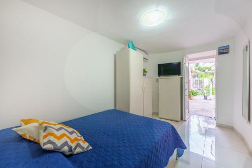 Schlafzimmer mit einem blauen Bett und einem Kühlschrank in der Unterkunft casetta mariapia in Procida