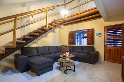 a living room with a couch and a staircase at Casa Ferreira Cumbuco in Caucaia