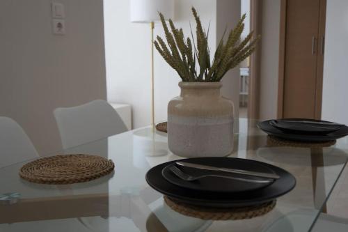 a glass table with plates and a vase on it at Central Delight in Chalkida