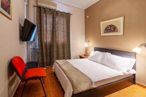 a bedroom with a bed and a red chair at Geo city center room in Athens