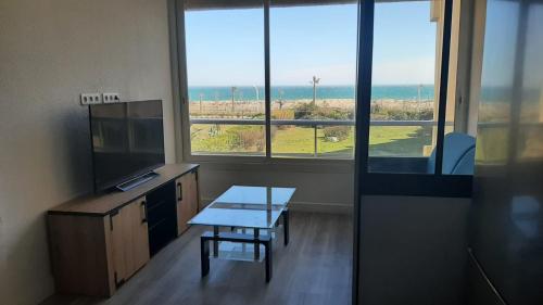 un bureau avec un bureau, une table et une fenêtre dans l'établissement Appartement vue exeptionnelle sur la mer 6 personnes, au Barcarès