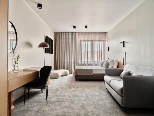 ein Hotelzimmer mit einem Bett, einem Sofa und einem Schreibtisch in der Unterkunft Hoppen House Apartamenty w centrum miasta in Radom