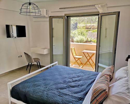 een slaapkamer met een bed en een glazen schuifdeur bij EmMi Houses in Ária