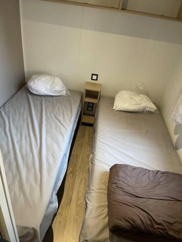 Cette petite chambre comprend 2 lits jumeaux. dans l'établissement Mobil-Home Camping 5* Montalivet, à Vendays-Montalivet