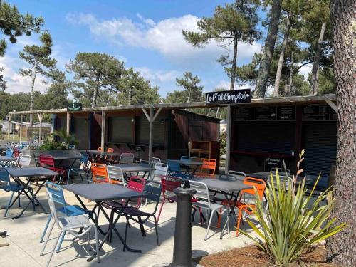 - un bouquet de tables et de chaises devant un restaurant dans l'établissement Mobil-Home Camping 5* Montalivet, à Vendays-Montalivet