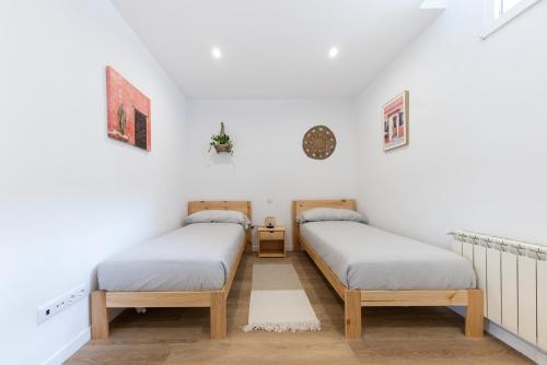 Habitación con 2 camas individuales y paredes blancas. en Apartamento con Jardín en el Oviedo Antiguo, en Oviedo