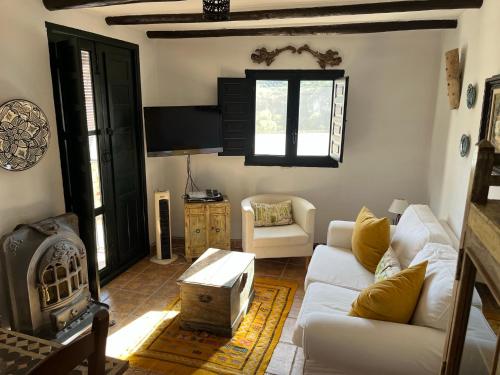 a living room with a white couch and a fireplace at Casa idrisi in Albuñuelas