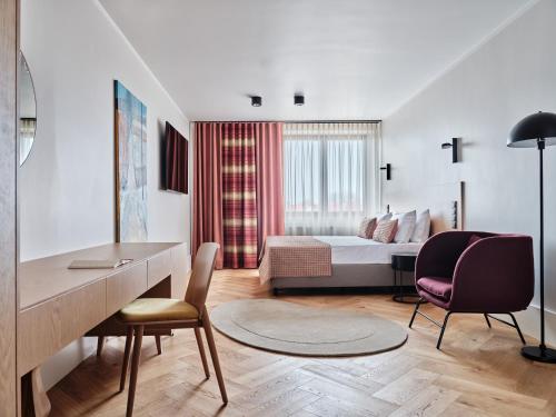 Cette chambre comprend un lit, un bureau et des chaises. dans l'établissement Hoppen House Apartamenty w centrum miasta, à Radom