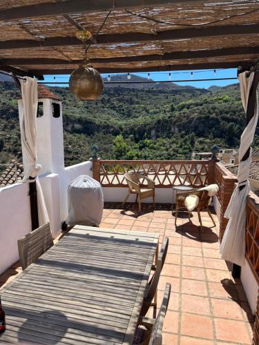 a patio with a table and chairs and a view at Casa idrisi in Albuñuelas