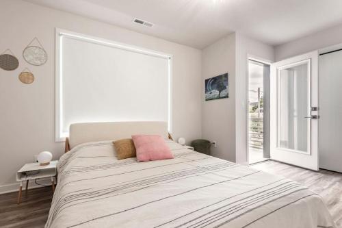 1 dormitorio blanco con 1 cama grande con almohadas rosas en Comfy Family Home, Walkable Neighborhood + Patio!, en Portland