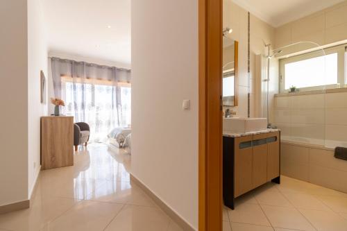 La salle de bains est pourvue d'un lavabo et d'un miroir. dans l'établissement Luxury Villa Albufeira, à Albufeira