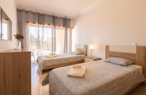 Cette chambre comprend 2 lits et une fenêtre. dans l'établissement Luxury Villa Albufeira, à Albufeira