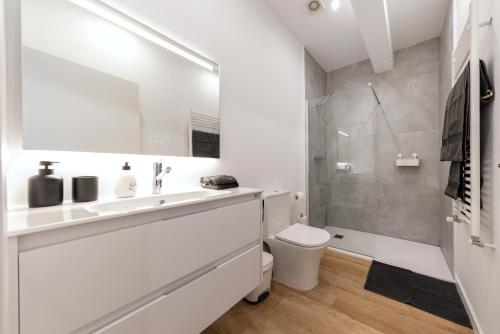 a white bathroom with a toilet and a shower at Apartamento con Jardín en el Oviedo Antiguo in Oviedo