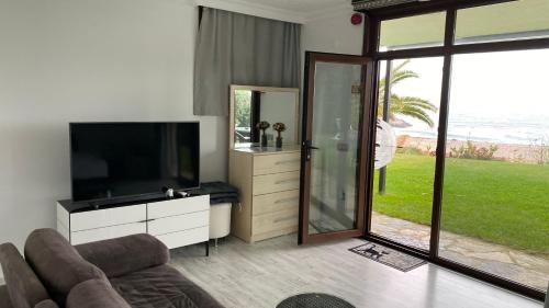 a living room with a flat screen tv and a couch at Palm Beach Şile Villa Hotels in Istanbul
