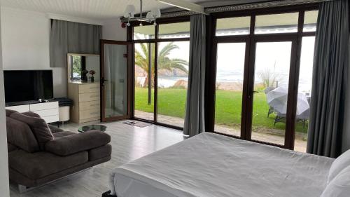 a bedroom with a bed and a couch and a television at Palm Beach Şile Villa Hotels in Istanbul