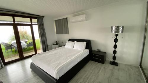 a bedroom with a bed with white sheets and a window at Palm Beach Şile Villa Hotels in Istanbul