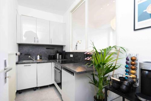 a white kitchen with white cabinets and a sink at Comfy Apartment Heart of Mannheim in Mannheim