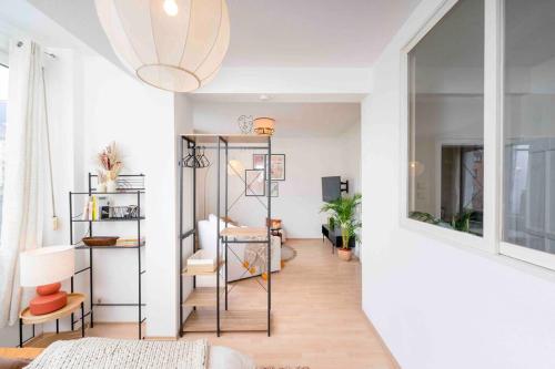 un soggiorno con pareti bianche e una grande finestra di Comfy Apartment Heart of Mannheim a Mannheim