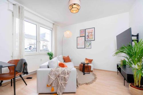 a living room with a white couch and a table at Comfy Apartment Heart of Mannheim in Mannheim