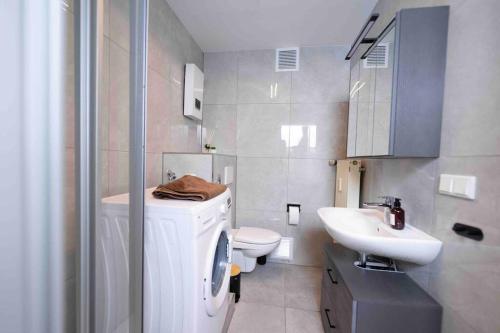 bagno con servizi igienici bianchi e lavandino di Comfy Apartment Heart of Mannheim a Mannheim