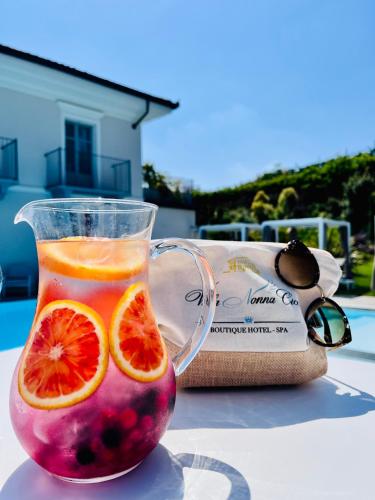 a drink in a glass with orange slices in it at Villa Nonna Cicci Boutique Hotel - SPA in Cisterna dʼAsti