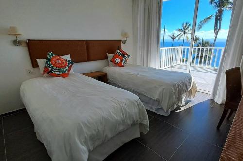 2 camas en una habitación de hotel con vistas al océano en Apto. en condominio con playa privada., en Santa Bárbara de Samaná