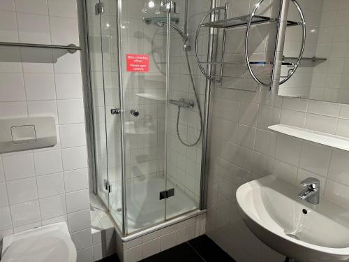 a bathroom with a glass shower and a sink at Appart Laijola in Gaschurn