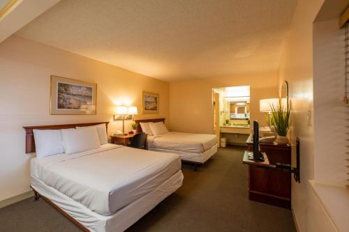 ein Hotelzimmer mit 2 Betten und einem TV in der Unterkunft Tahiti Inn in Ocean City