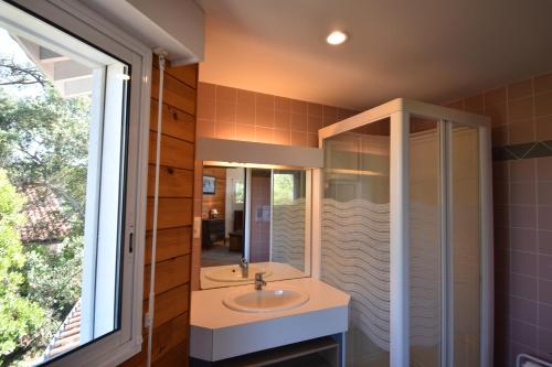 une salle de bain avec un lavabo et un miroir dans l'établissement Sauges - Hossegor belle villa avec vue océan dans secteur calme entre lac et océan sur terrain non clos d'environ 1500 mètres car, à Soorts-Hossegor