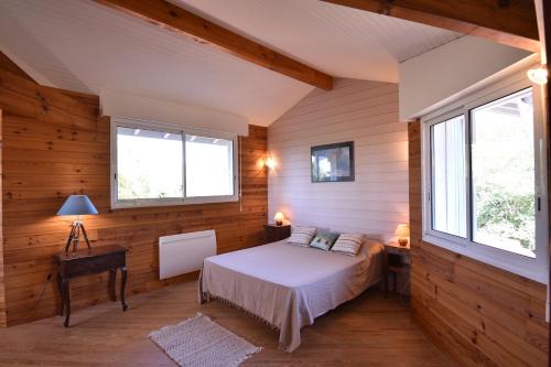 une chambre avec un lit dans une pièce aux murs en bois dans l'établissement Sauges - Hossegor belle villa avec vue océan dans secteur calme entre lac et océan sur terrain non clos d'environ 1500 mètres car, à Soorts-Hossegor