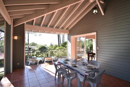 une salle à manger avec une table et des chaises sur un patio dans l'établissement Sauges - Hossegor belle villa avec vue océan dans secteur calme entre lac et océan sur terrain non clos d'environ 1500 mètres car, à Soorts-Hossegor