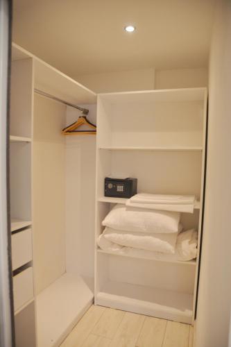 a walk in closet with white shelves and towels at Boutique Citadel in Eforie Nord