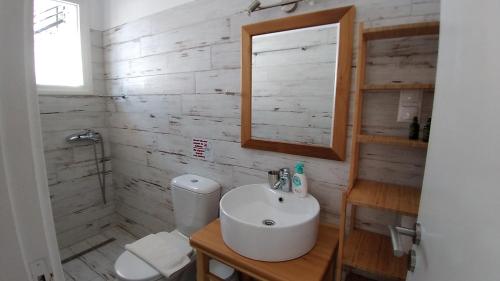 een witte badkamer met een wastafel en een spiegel bij George and Danai apartments in Kassiopi