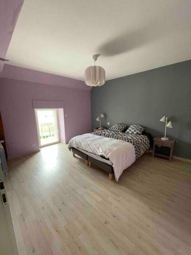 - une chambre avec un lit dans un mur violet dans l'établissement Longère au coeur du vignoble de Champagne, à Lachy