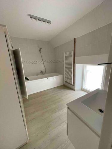une salle de bain blanche avec une baignoire et un lavabo dans l'établissement Longère au coeur du vignoble de Champagne, à Lachy