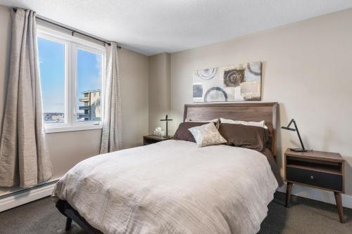 a bedroom with a bed and a large window at Superb 2 bedroom downtown with river view in Saskatoon