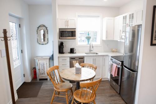 kuchnia ze stołem, krzesłami i lodówką w obiekcie 2Bdrm Victorian Style Tiny Home - long stays U7 w mieście Burlington