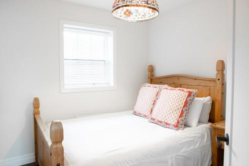 sypialnia z łóżkiem, oknem i żyrandolem w obiekcie 2Bdrm Victorian Style Tiny Home - long stays U7 w mieście Burlington