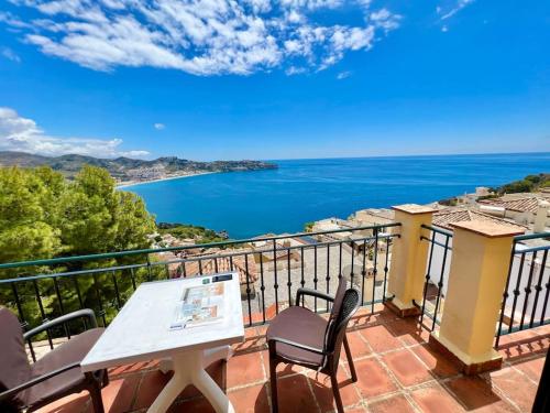 a balcony with a table and chairs and a view of the ocean at Chalet Tropical Bay Views in La Herradura