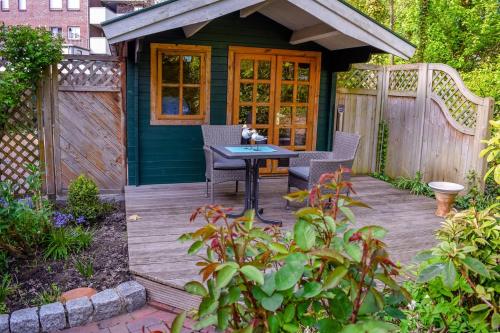 a small house with a table and chairs on a deck at das Fischerhus in Bensersiel