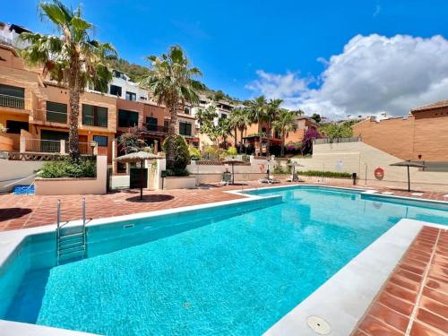 una piscina en un apartamento con palmeras en Chalet Tropical Bay Views, en La Herradura