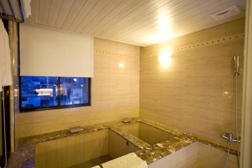 Resort One Hotel في جياوكسي: حمام مع حوض استحمام مع نافذة